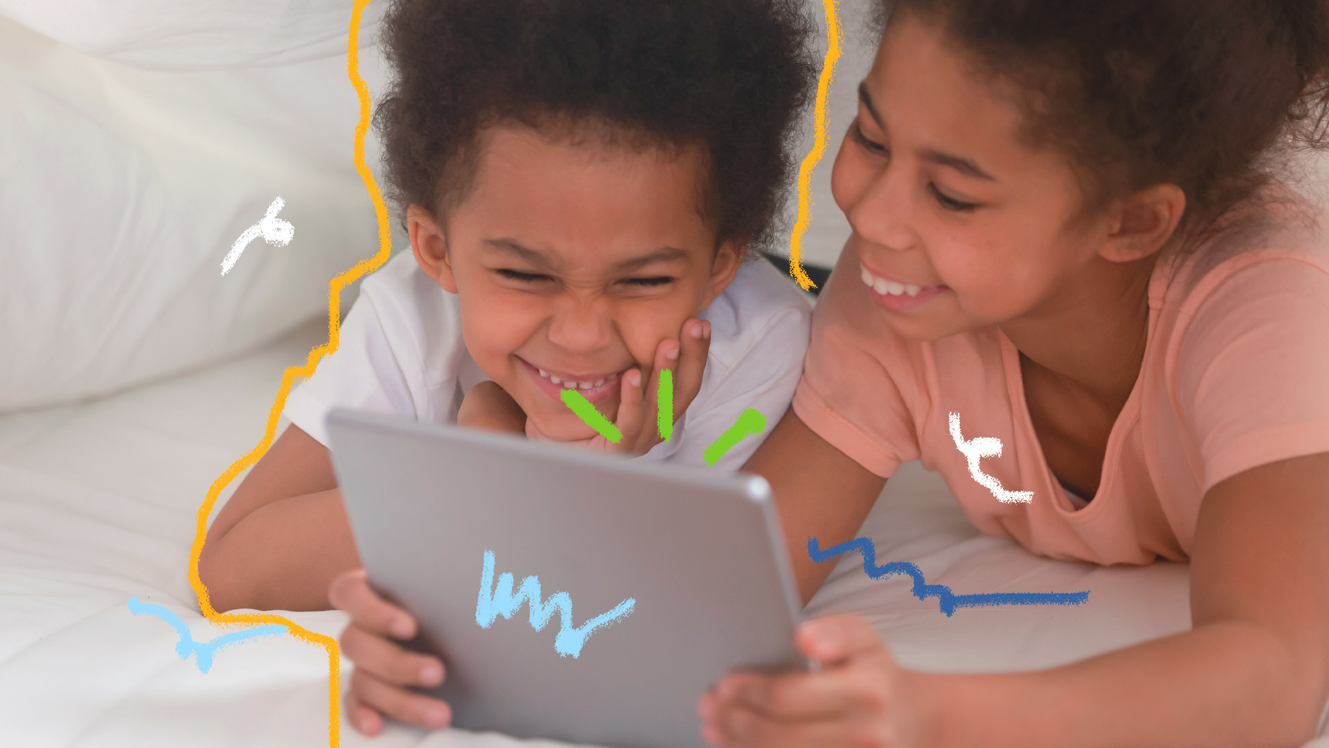 Imagem de duas crianças negras estão vendo algum conteúdo em um tablet e sorrindo.