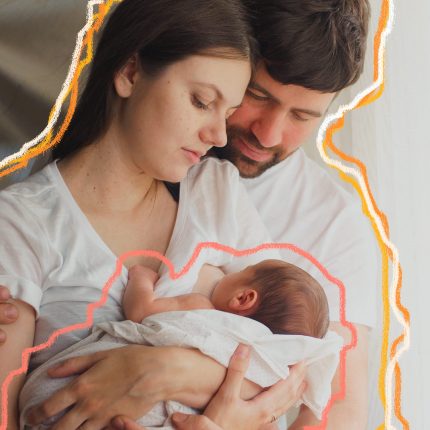 Imagem de um família branca: mãe de cabelos pretos e lisos segura o bebê no colo, e o pai está ao lado