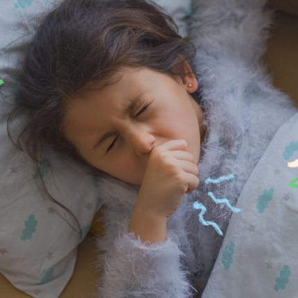 Imagem de uma menina levando a mão à boca enquanto tosse. Ela está deitada em sua cama embaixo do lençol, que tem estampa de nuvens.