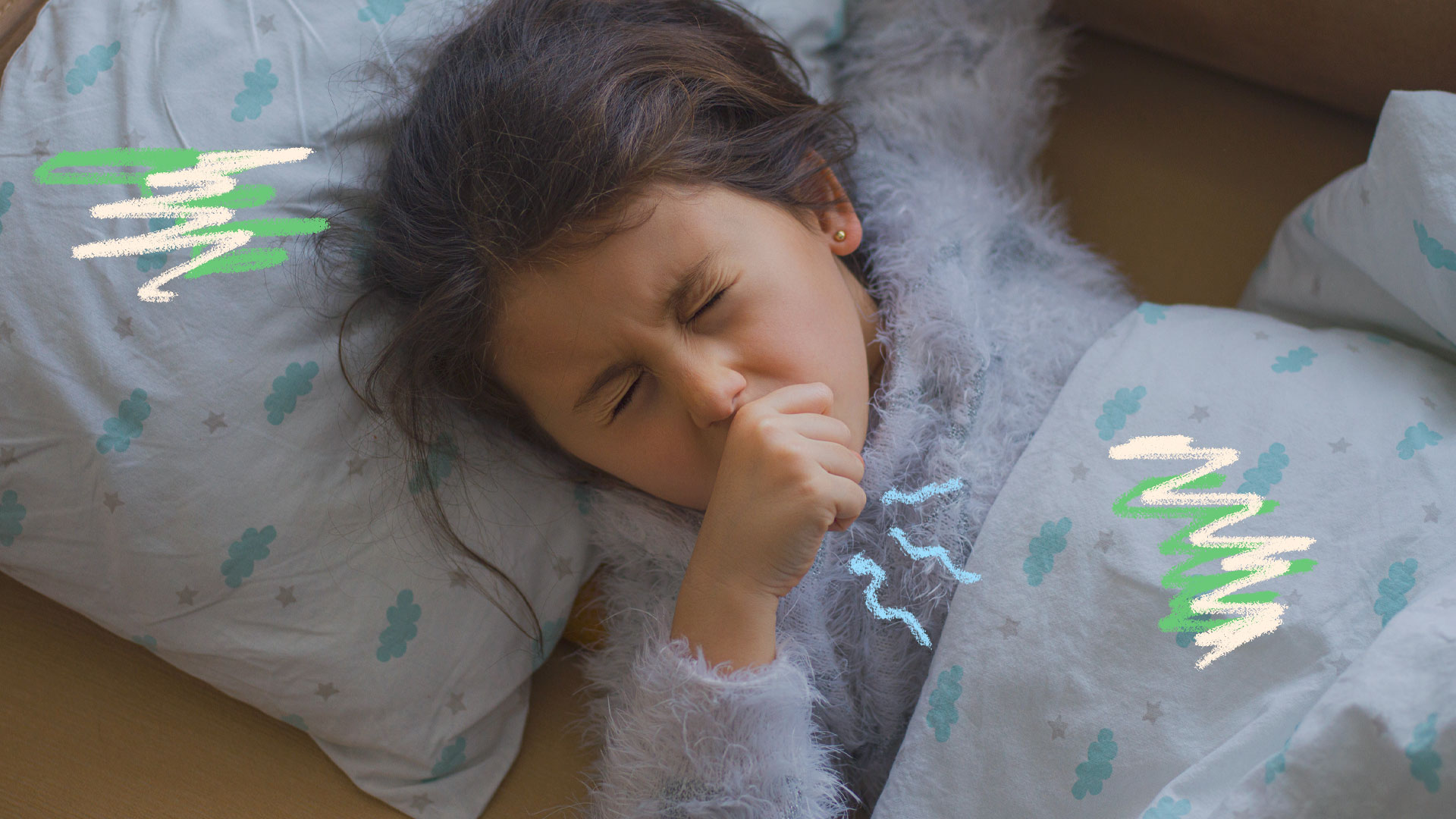 Imagem de uma menina levando a mão à boca enquanto tosse. Ela está deitada em sua cama embaixo do lençol, que tem estampa de nuvens.