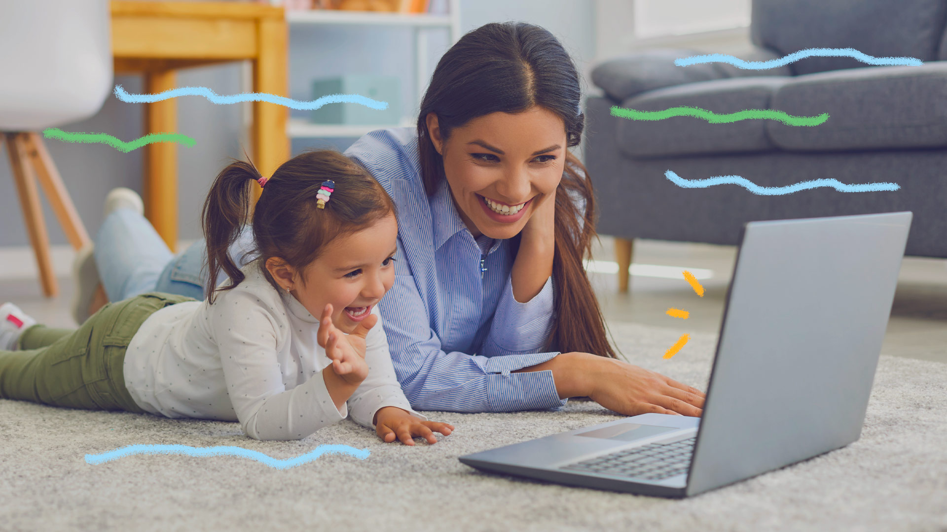 Canais infantis Youtube: foto de mãe e filha, ambas estão deitadas de bruços no chão da sala, sorriem e assistem a vídeos através de um notebook.