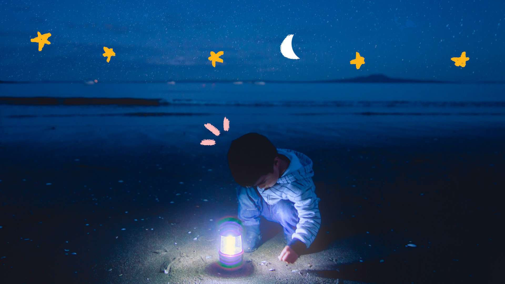 Foto de um menino na praia à noite. Ele brinca com um abajur e ao redor há estrelas e luas desenhadas