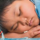 Obesidade infantil: um menino está deitado de bruços sobre as mãos
