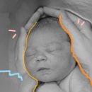 Músicas para o parto: Foto em preto e branco mãos femininas envolvendo um bebê recém-parido