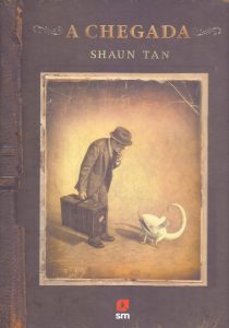 Capa do livro “A chegada”, de Shaun Tan, com ilustração de homem de terno, chapéu e maleta, que olha um animal branco a sua frente.