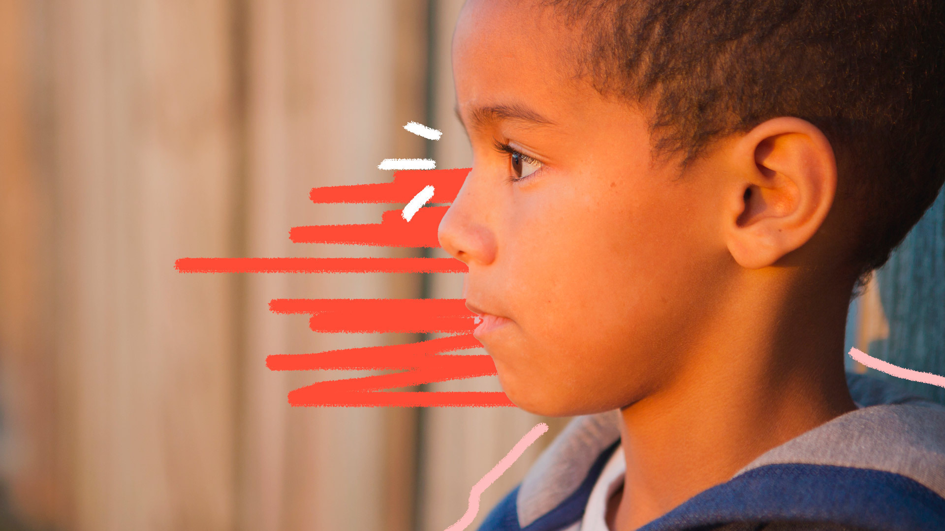 Perfil de um menino negro olhando para o lado esquerdo da tela.