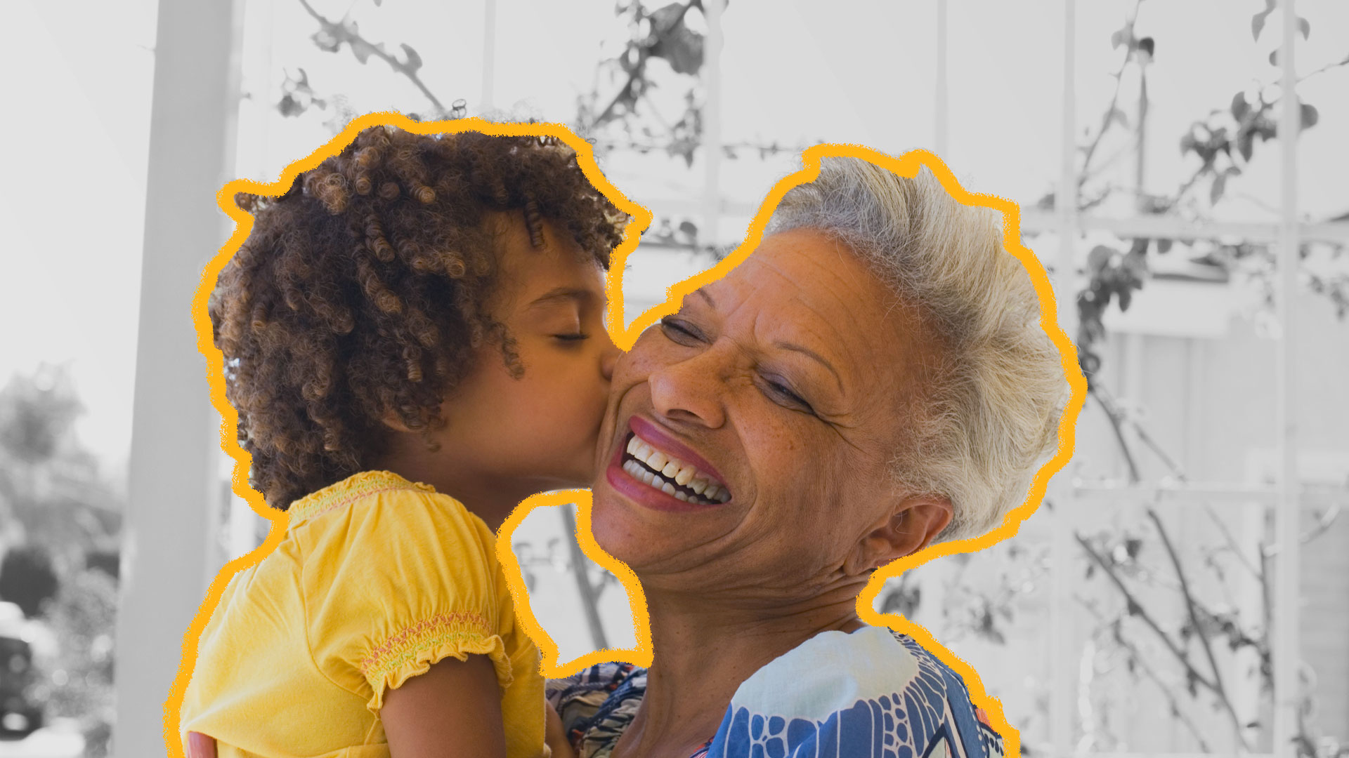 filmes sobre envelhecimento: Avó negra de cabelos grisalhos e sorrindo recebe um beijo na bochecha de seu neto, também negro e de cabelos crespos, vestindo camiseta amarela