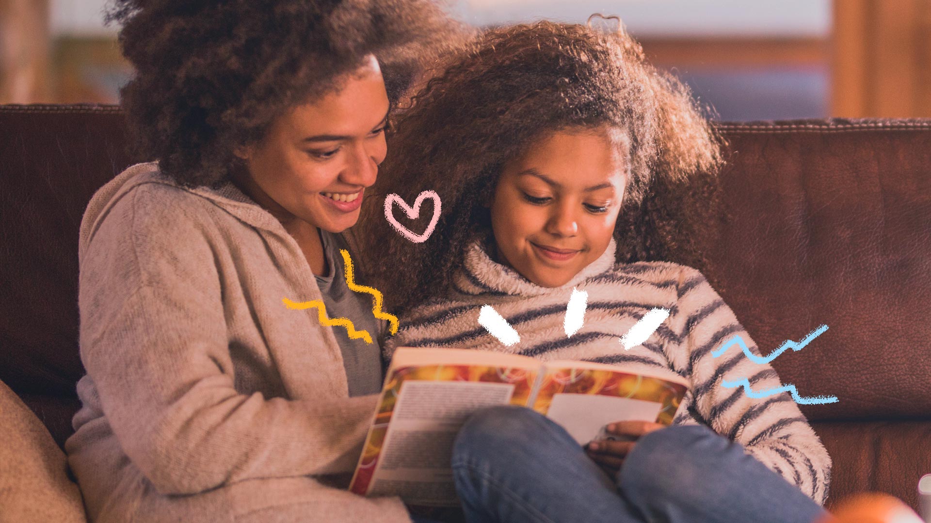 Foto de uma mulher e uma menina lendo juntas o mesmo livro. Elas estão sentadas no sofá.