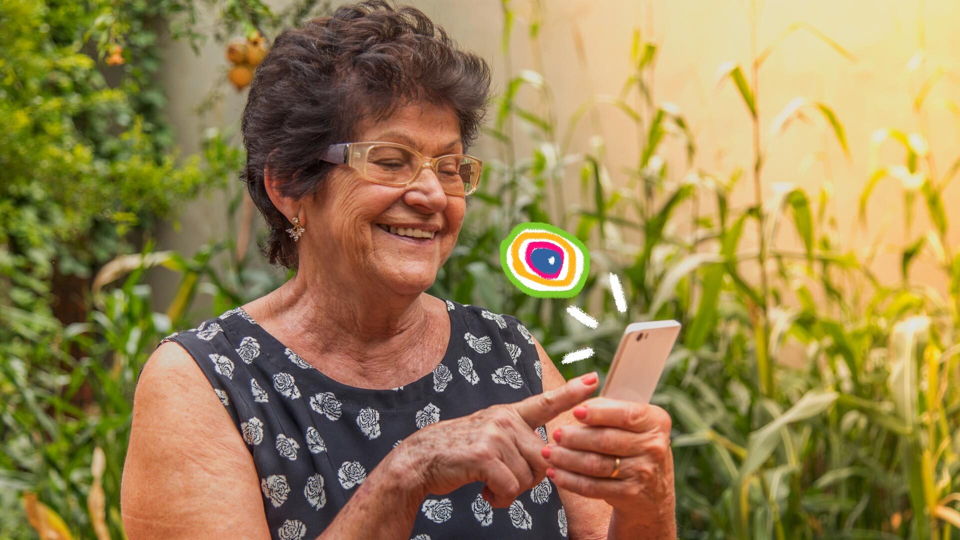 Uma senhora de cabelos grisalhos e óculos está sorrindo enquanto mexe no celular. No meio a imagem, aparece a logo do Lunetas