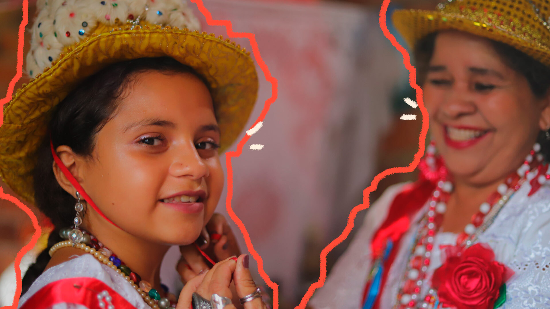 Uma menina sorri, enquanto uma mulher amarra nela um chapéu dourado com plumas brancas. Ambas vestem roupas típicas da festa da Marujada de Bragança