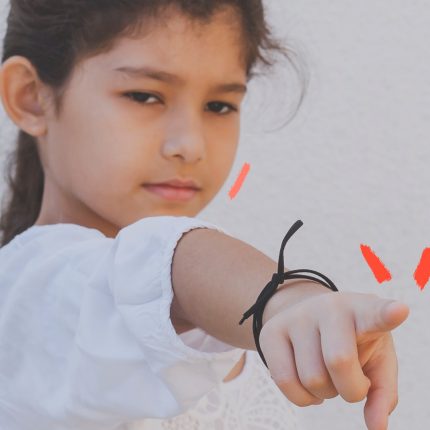 Foto de uma menina apontando o dedo. Ela veste branco, está com o cabelo preso e tem uma pulseira no braço. Texto sobre cancelamento e infância