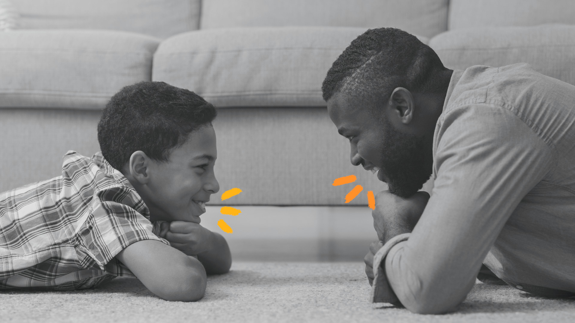 Jogo de palavras: foto em preto e branco de pai e filho deitados de bruços na sala de estar, olhando um para o outro e falando