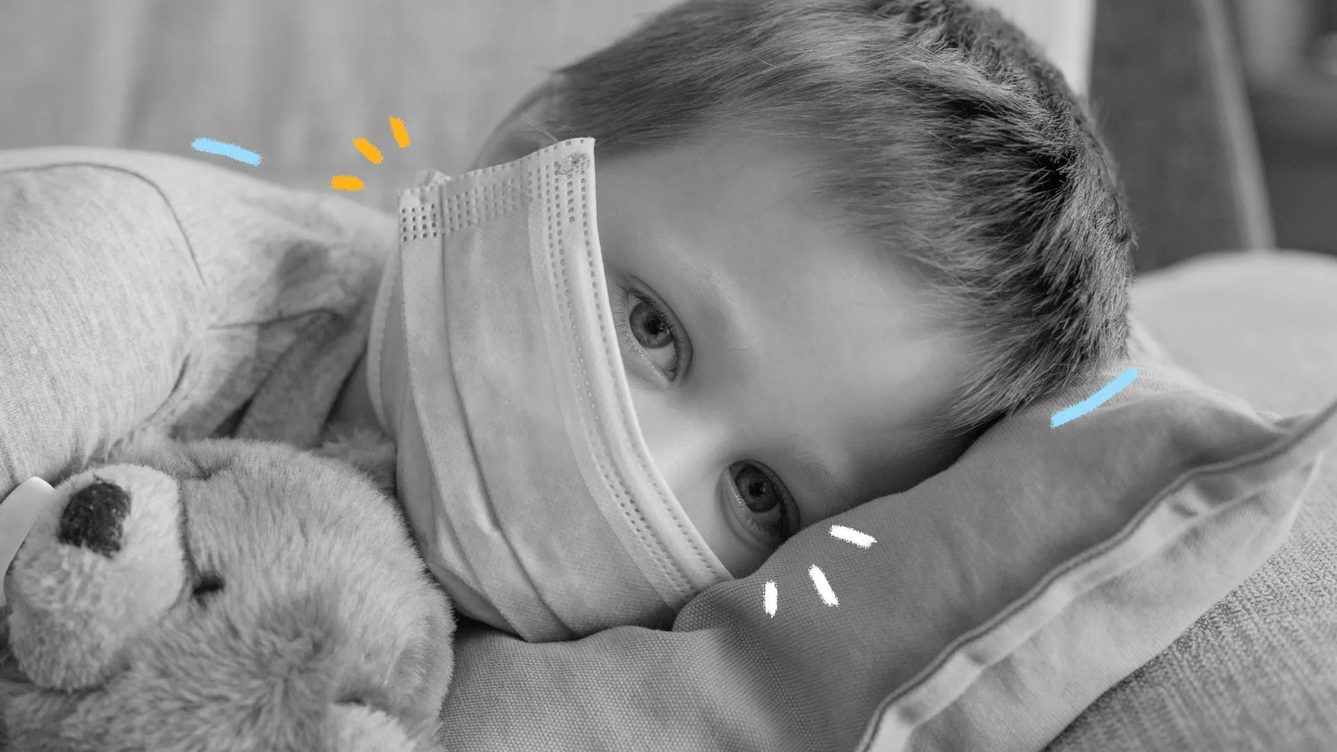Foto em preto e branco de uma criança, com máscara, deitada em um leito, com olhar triste