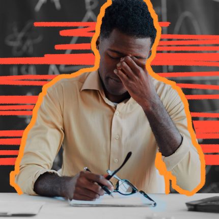 Educação na pandemia: professor sentado, com uma pilha de papéis na mesa, o óculos em uma mão e a outra coçando os olhos