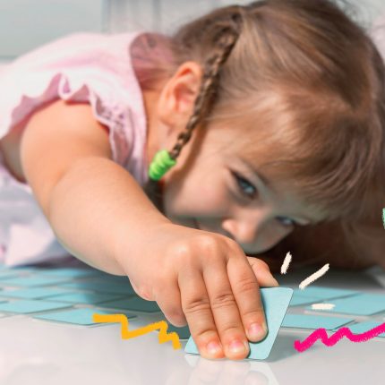 Foto de uma criança deitada no chão brincando de jogo da memória