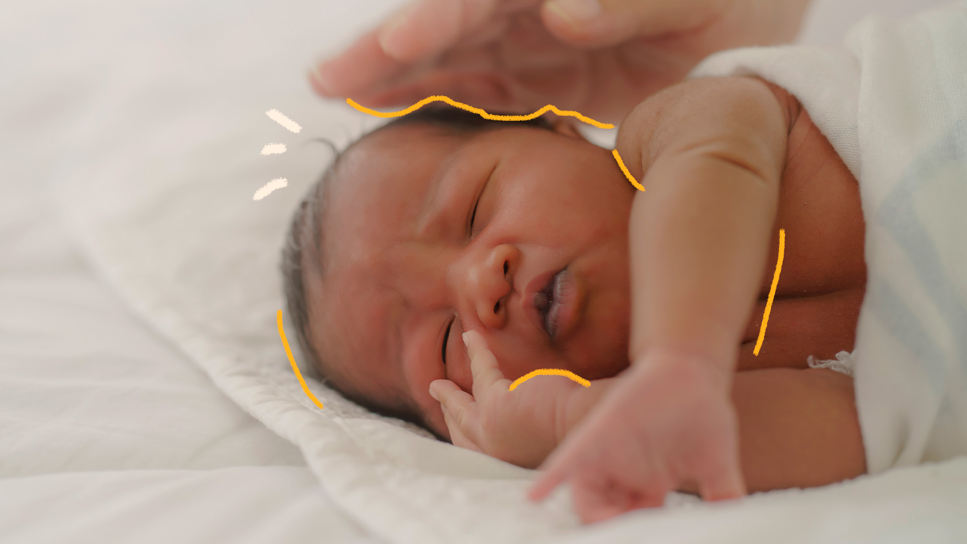 foto de um bebê recém-nascido dormindo, e uma mão adulta sobre sua cabeça