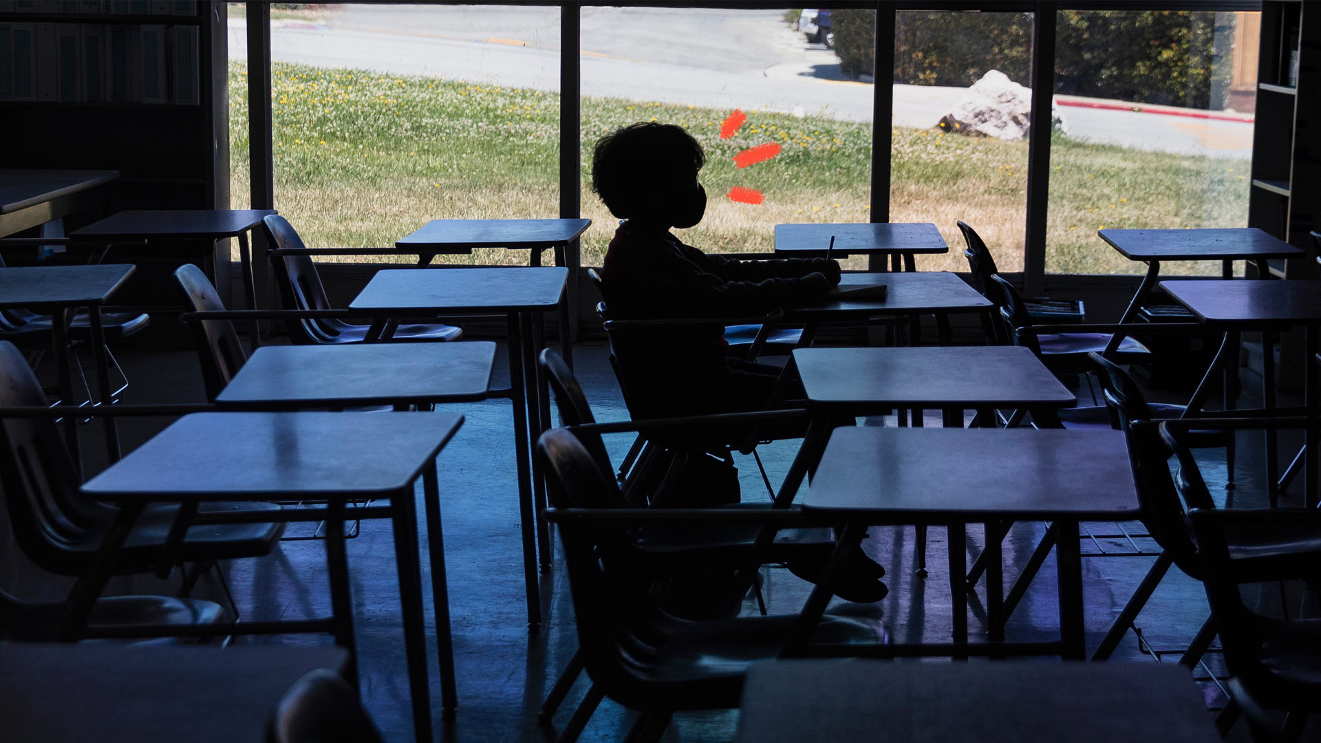 Uma criança está em uma sala de aula vazia