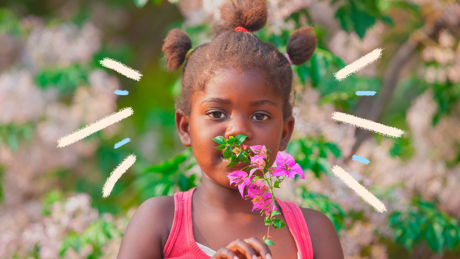 Uma menina com o cabelo preso em três partes segura um ramo de primavera em frente ao rosto. A matéria é sobre brincadeiras com elementos da natureza