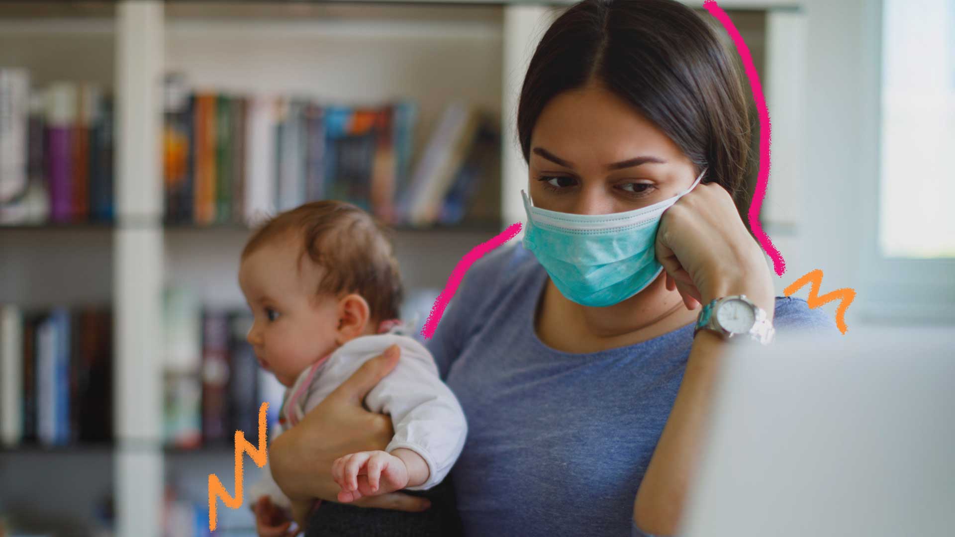 Famílias na pandemia: Uma mãe segura seu bebê no colo. Ela usa máscara. Ao fundo, há uma estante de livros