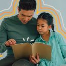 Pai e filha leem juntos um livro sem nada escrito ou desenhado na capa