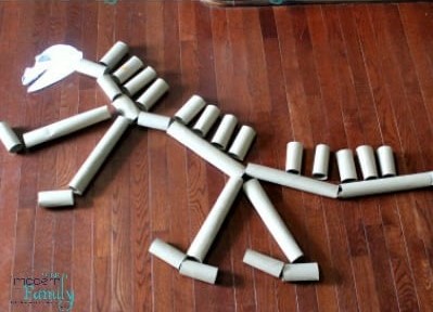 Brincadeiras de dinossauros: vários rolos de papel higiênico enfileirados formando um esqueleto de dinossauro