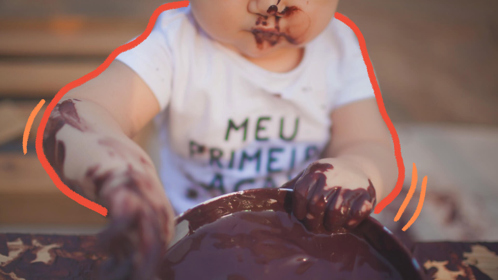 Close das mãos de um bebê, lambuzadas de açaí que está numa tigela