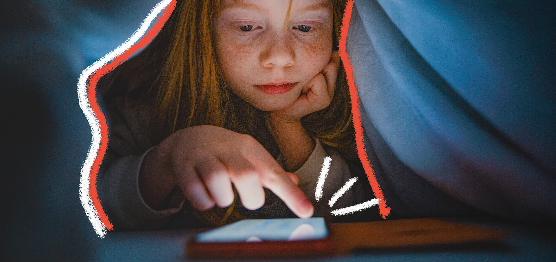 Uma menina ruiva está deitada na cama, embaixo de um lençol, mexendo na tela do celular