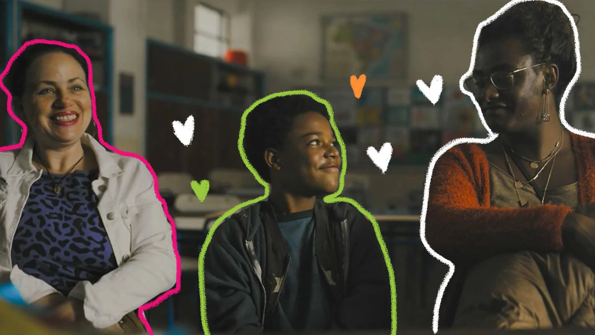 Uma família está sentada em uma sala de aula: a mãe Leide, mulher branca, à direita, está sorrindo; Gersinho, menino negro, ao centro, que olha sorrindo para sua outra mãe, Cassandra, mulher negra e trans, que está à esquerda