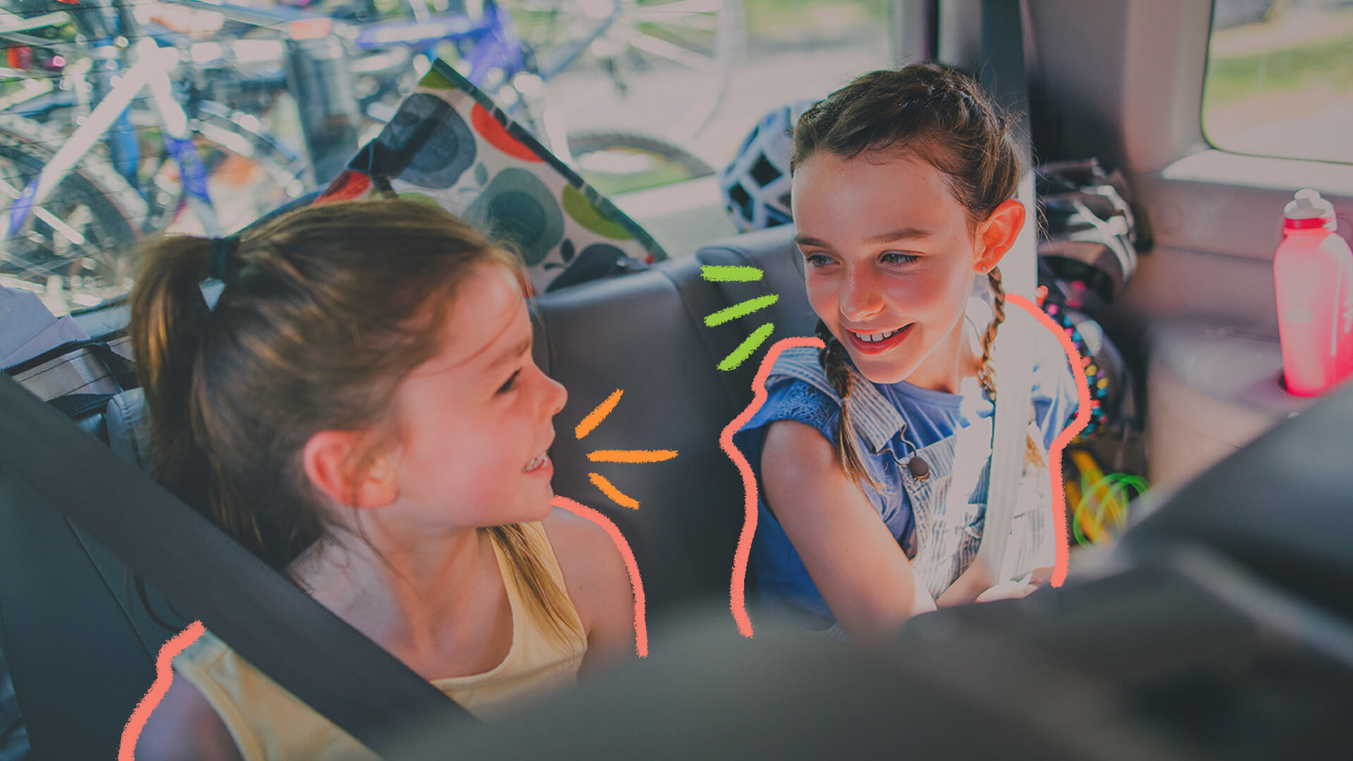 Foto de duas meninas sentadas no banco de detrás do carro, usando cinto de segurança. Elas conversam e se divertem com brincadeiras enquanto esperam a viagem terminar.