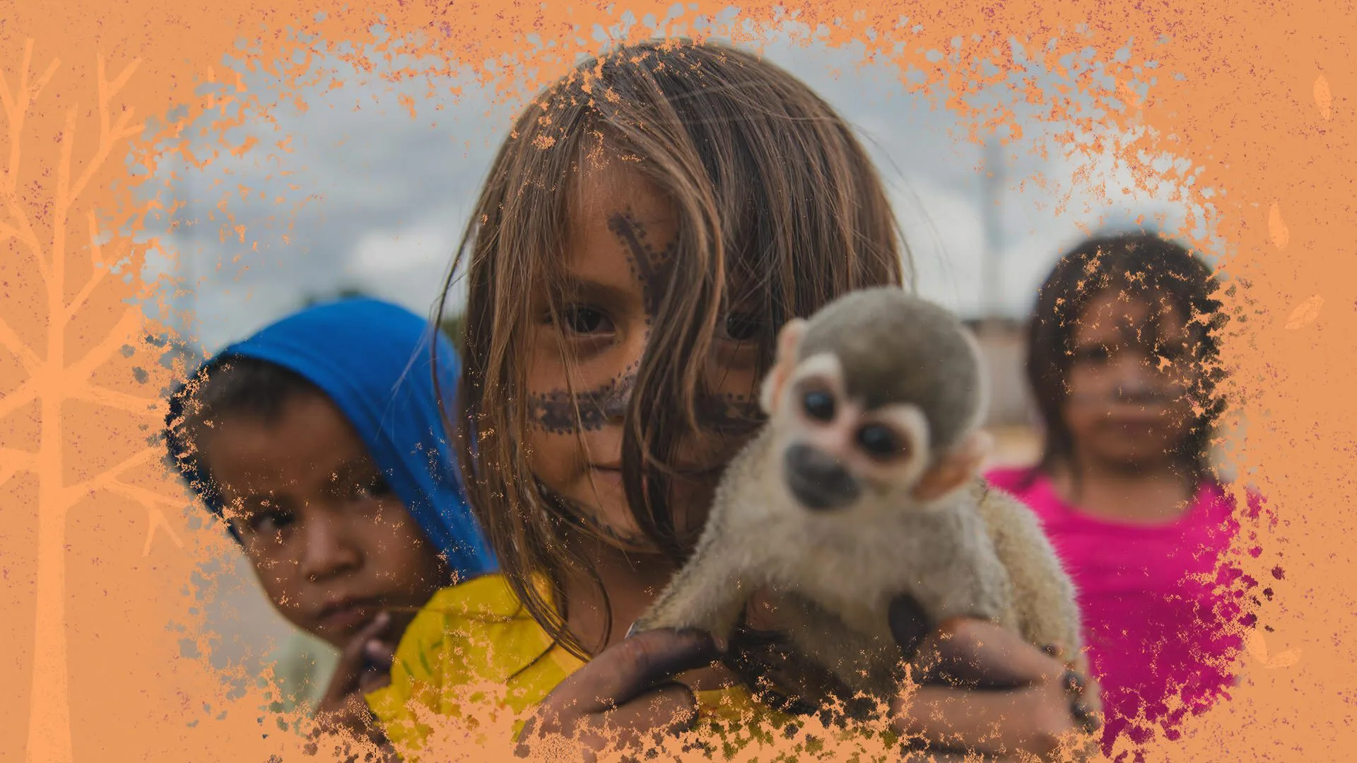 Três crianças indígenas posam para foto, uma delas segura um macaquinho