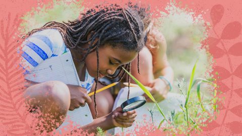 Projetos de meio ambiente: na foto, uma menina negra olha para a terra com uma lupa de aumento. Ela segura um caderno e um lápis. A imagem possui uma intervenção de moldura na cor rosa.