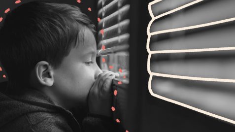 Foto em preto e branco de um menino olhando através de uma persiana semifechada