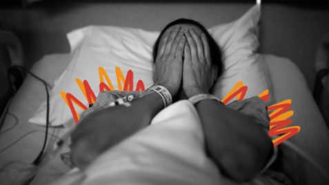 Na foto, uma mulher cobre o rosto com as mãos, deitada em uma cama de hospital. A imagem está em preto e branco e possui intervenções de rabiscos nas cores laranja e vermelho.