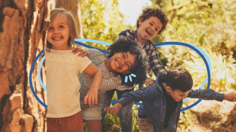Cultura da infância: Um grupo de quatro crianças, duas meninas e dois meninos, estão brincando ao ar livre