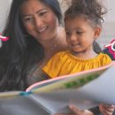 Leia para uma criança: na imagem, mãe e filha leem um livro juntas. A imagem possui intervenções de rabiscos coloridos.