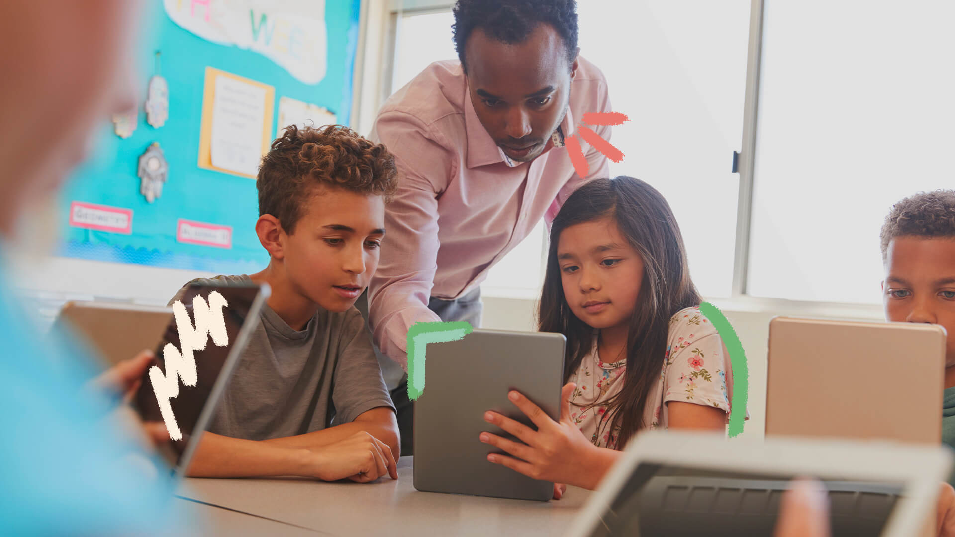Plataforma auxilia educadores a orientarem crianças na internet: na foto, crianças olham para um tablet enquanto são orientadas por um professor. A imagem possui intervenções de rabiscos coloridos.