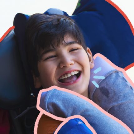 Na imagem, um menino em uma cadeira de rodas sorri. Ele é branco e possui cabelos escuros. A imagem possui intervenções de rabiscos coloridos.