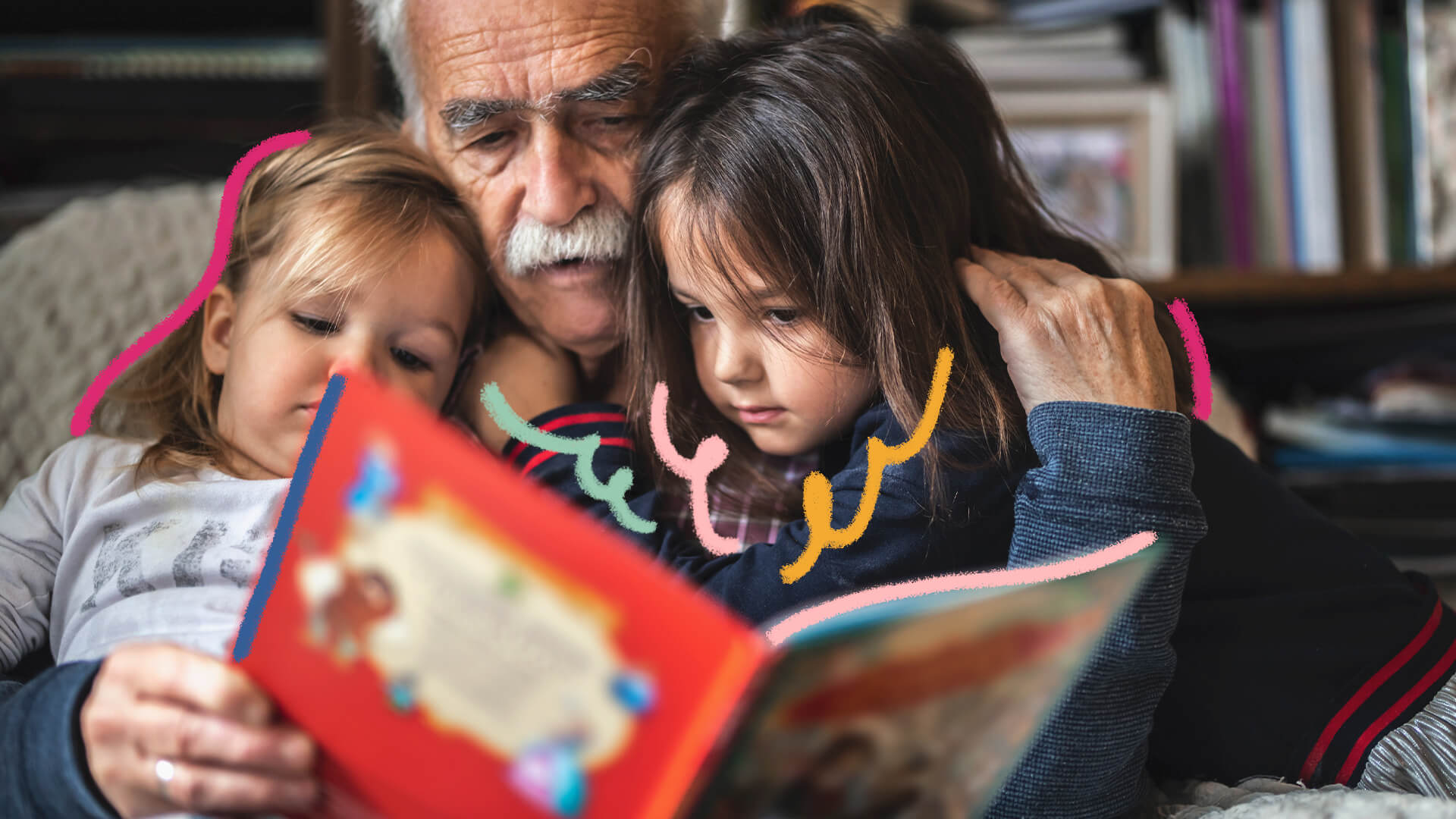 Na foto, um avô lê um livro de histórias com as netas. A imagem possui intervenções de rabiscos coloridos.
