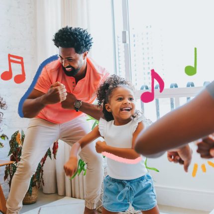 Garatujas sonoras: foto de uma família de pessoas negras (dois adultos e duas meninas), que dançam na sala de casa.