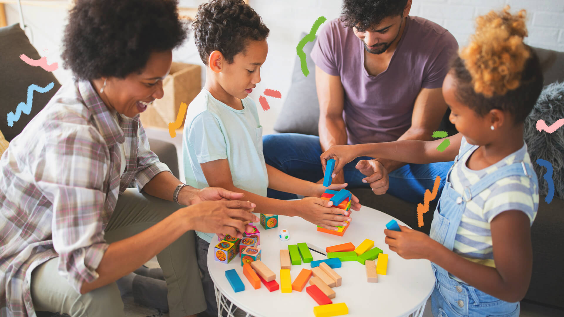 Na foto, uma família negra composta por mãe, pai e dois filhos (um menino e uma menina). Eles brincam em uma mesa com dados e objetos de montar. A imagem possui intervenções de rabiscos coloridos.