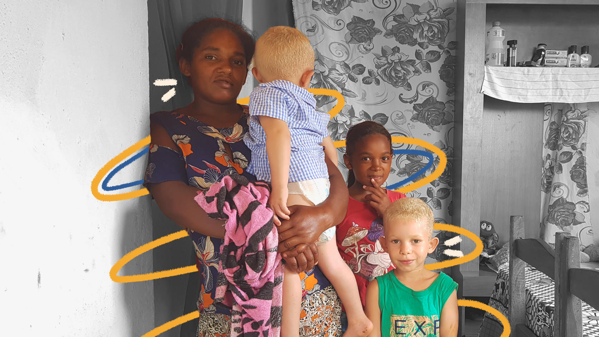 Foto de uma família quilombola: a mãe e a filha mais velha são negras e os dois meninos são negros albinos. Eles vestem roupas coloridas e o fundo da foto está em preto e branco