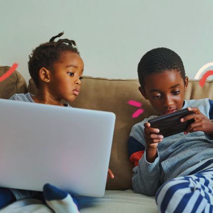 Duas crianças negras estão sentadas em um sofá bege. Elas brincam com um notebook e um celular. A imagem possui intervenções de rabiscos coloridos.