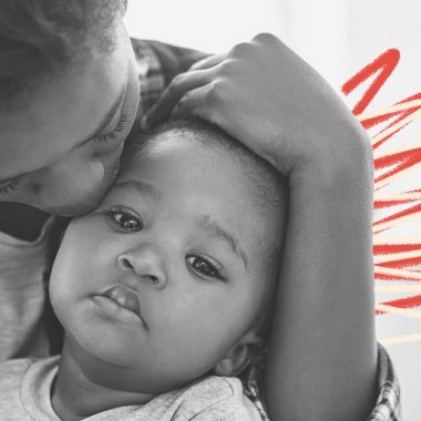 Marcas do racismo: Foto em preto e branco de uma mãe negra beijando seu bebê negro e intervenções de rabisco em vermelho