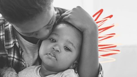 Marcas do racismo: Foto em preto e branco de uma mãe negra beijando seu bebê negro e intervenções de rabisco em vermelho