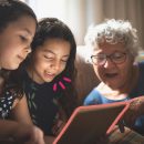 TIC kids online brasil 2021: na imagem, duas meninas olham para um tablet acompanhadas da avó.