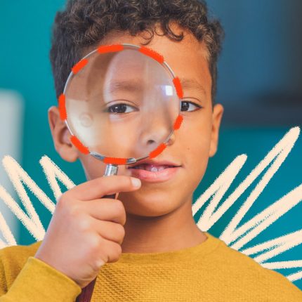 Um menino negro vestindo uma blusa amarela segura uma lupa em frente ao olho