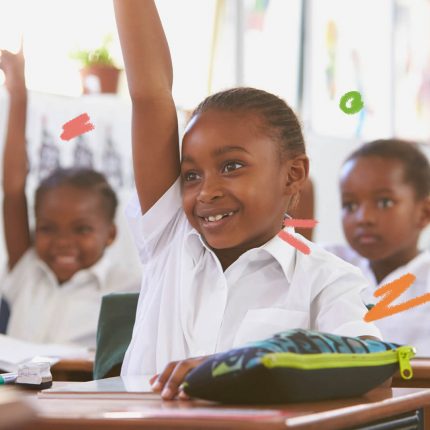 Sorrindo, crianças negras levantam o braço em uma sala de aula.