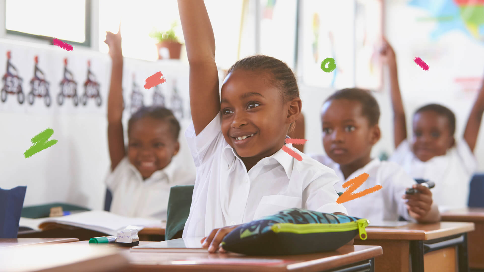 Sorrindo, crianças negras levantam o braço em uma sala de aula.