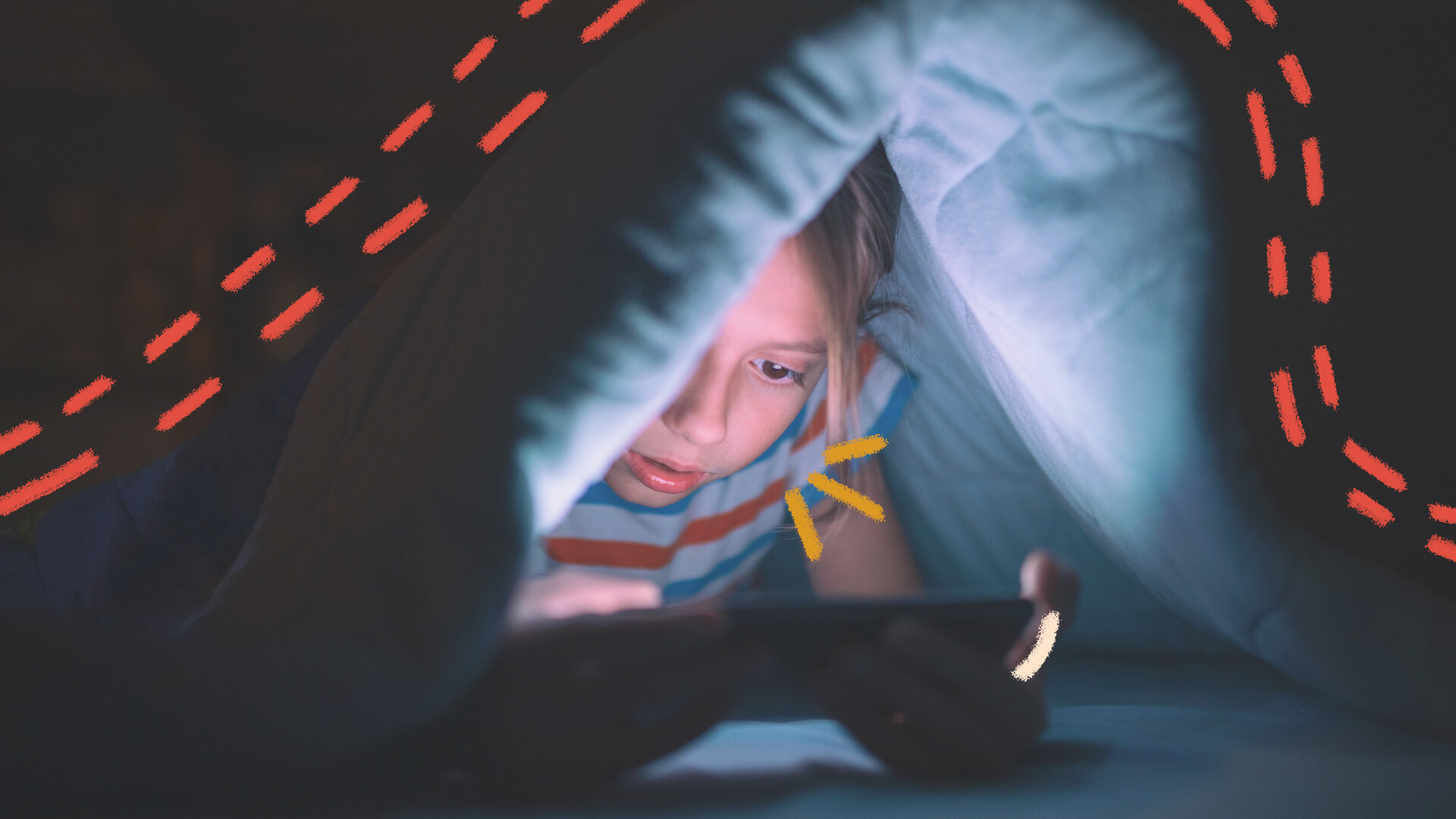 Nomofobia: foto de uma criança branca, que está embaixo de um cobertor e acessa o celular.