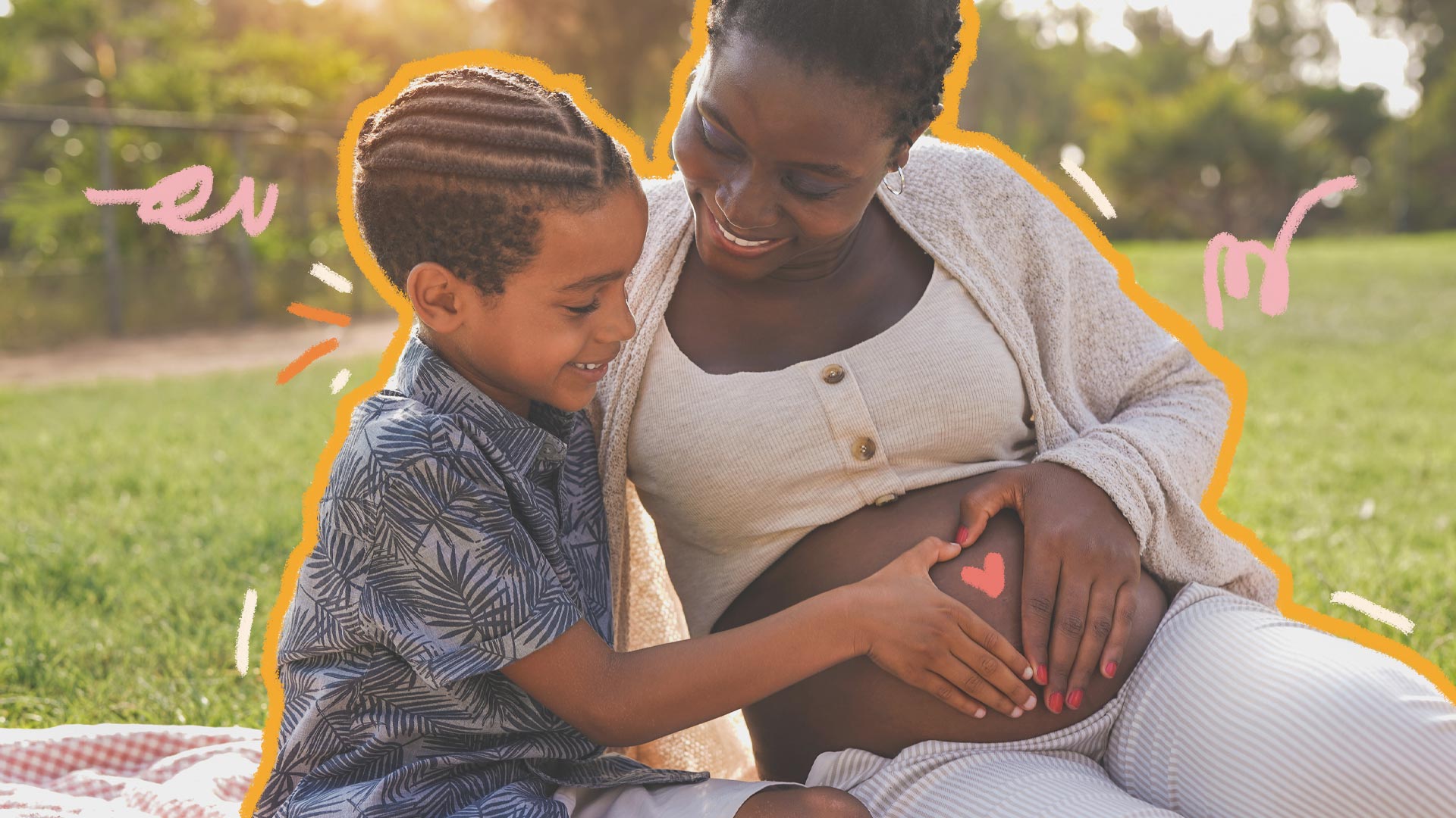 Uma mulher negra gestante está sentada no gramado, acompanhada do filho, também negro. O menino e a mulher fazem um coração com as mãos na barriga da mãe.